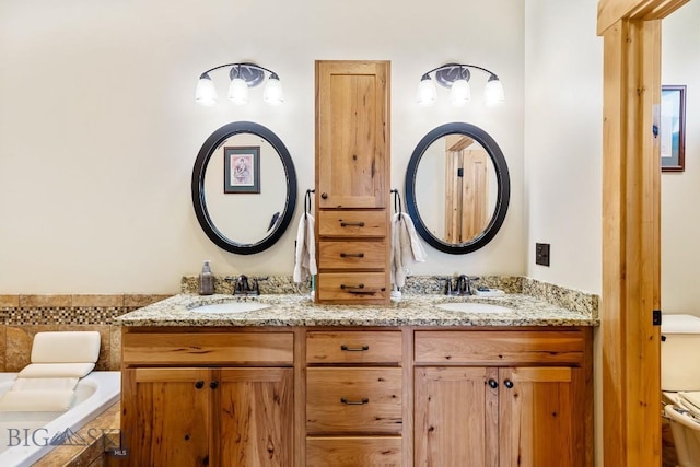 bathroom featuring double vanity, toilet, a relaxing tiled tub, and a sink