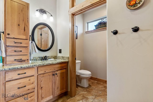 full bathroom with vanity, baseboards, and toilet