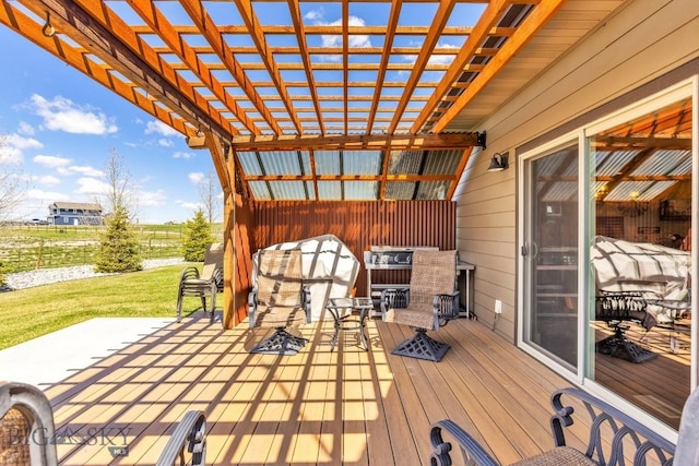 wooden terrace featuring a lawn, fence, and a pergola