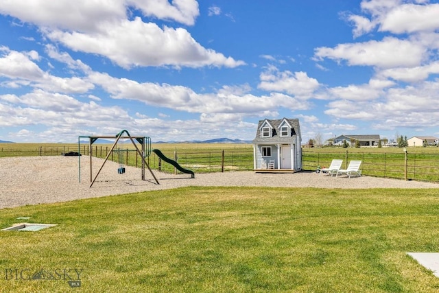 community play area with fence, an outbuilding, and a yard
