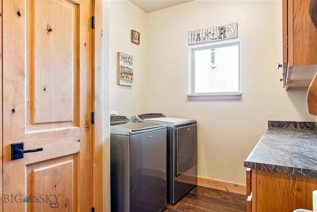 laundry room featuring baseboards, cabinet space, washing machine and dryer, and dark wood-style floors