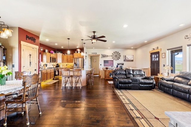 living area featuring dark wood-style flooring, a ceiling fan, and recessed lighting