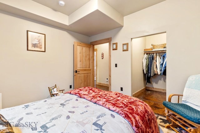 bedroom featuring a closet, baseboards, and a walk in closet