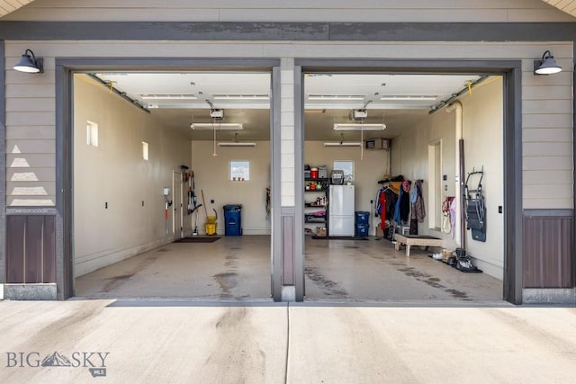 garage with a garage door opener and freestanding refrigerator