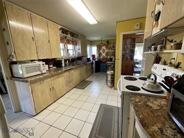 kitchen with dark countertops, open shelves, a sink, white appliances, and light tile patterned flooring