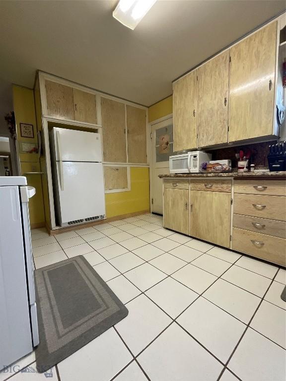 kitchen with light tile patterned flooring and white appliances