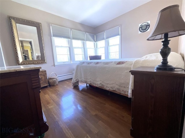 bedroom with dark wood-type flooring and a baseboard heating unit