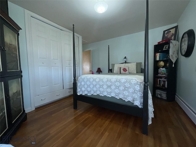 bedroom with dark wood-type flooring, baseboards, and a baseboard heating unit