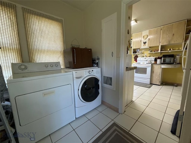 laundry area featuring laundry area, washing machine and dryer, and light tile patterned floors