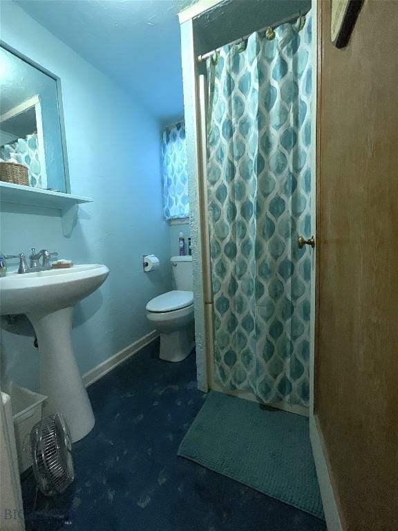 bathroom with a sink, baseboards, toilet, and a shower with shower curtain