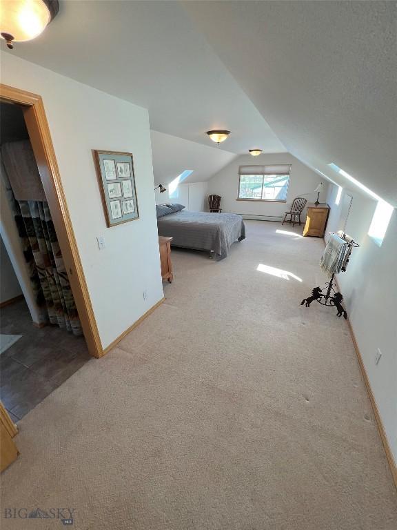 8265 Fowler Ln, Bozeman, MT 59718 - bedroom featuring carpet floors, vaulted ceiling, and baseboards