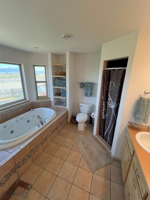 8265 Fowler Ln, Bozeman, MT 59718 - full bathroom with tile patterned floors, a jetted tub, toilet, a stall shower, and vanity