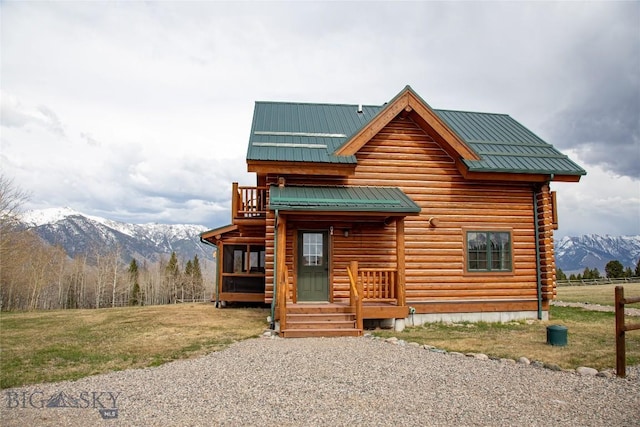 log-style house featuring a front yard, a mountain view, metal roof, and log exterior