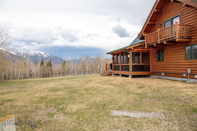 view of yard with a deck with mountain view and fence