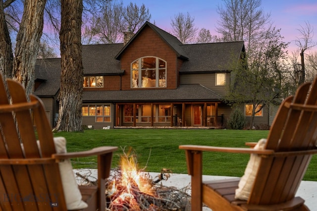 624 Rocking Horse Dr, Bozeman, MT 59718 - rear view of house with a lawn, a shingled roof, a fire pit, and a chimney