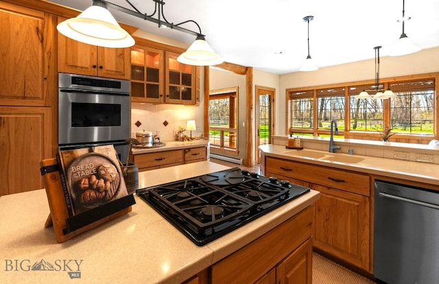 624 Rocking Horse Dr, Bozeman, MT 59718 - kitchen featuring hanging light fixtures, a sink, light countertops, stainless steel appliances, and glass insert cabinets