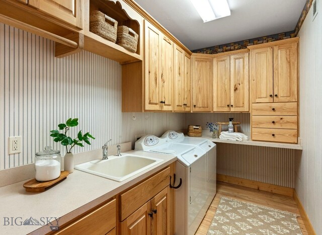 624 Rocking Horse Dr, Bozeman, MT 59718 - washroom featuring cabinet space, a sink, light wood-style floors, wallpapered walls, and washing machine and dryer