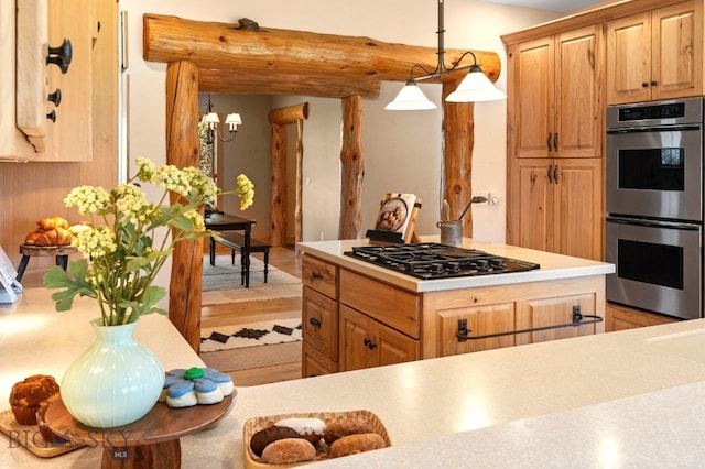 624 Rocking Horse Dr, Bozeman, MT 59718 - kitchen featuring hanging light fixtures, stainless steel double oven, black gas stovetop, light countertops, and light wood-type flooring