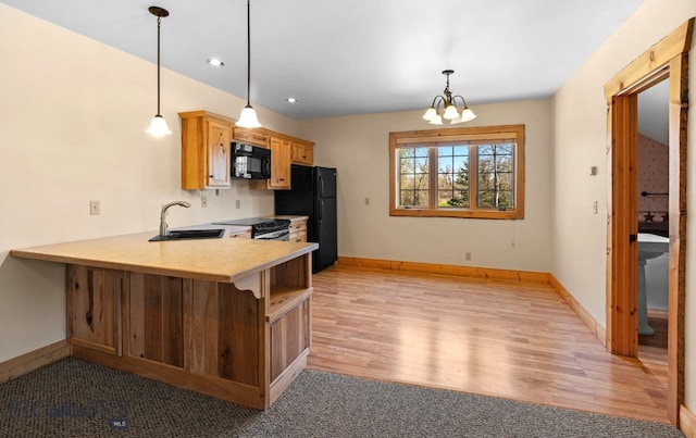 624 Rocking Horse Dr, Bozeman, MT 59718 - kitchen with a sink, baseboards, light countertops, black appliances, and a peninsula