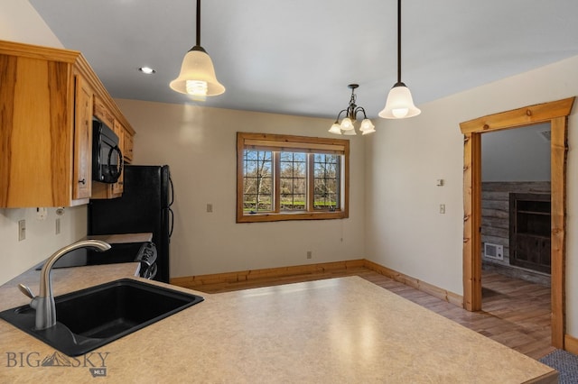 624 Rocking Horse Dr, Bozeman, MT 59718 - kitchen with black microwave, a fireplace, recessed lighting, light countertops, and a sink