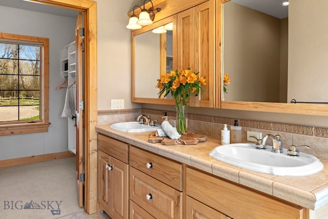 624 Rocking Horse Dr, Bozeman, MT 59718 - bathroom featuring double vanity, baseboards, and a sink