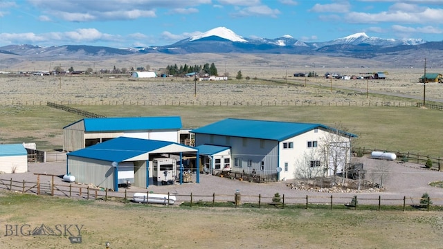 exterior space with fence, a mountain view, and a rural view