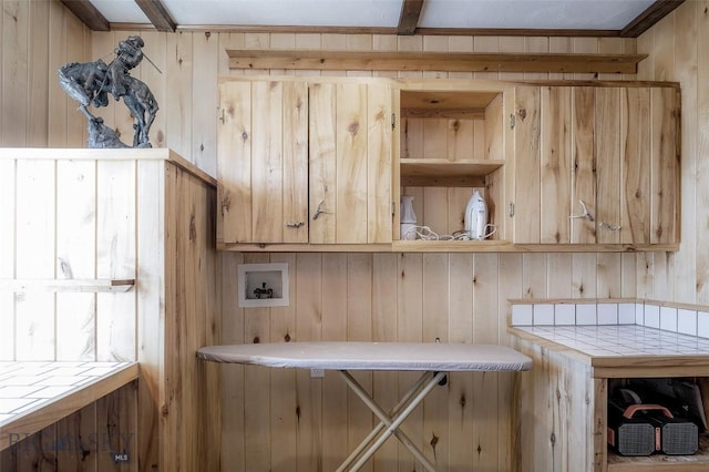 laundry area with hookup for a washing machine, cabinet space, and wooden walls