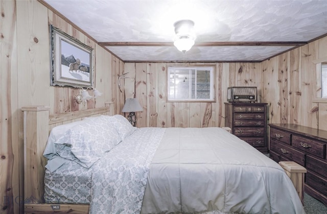 bedroom featuring crown molding, wooden walls, and multiple windows