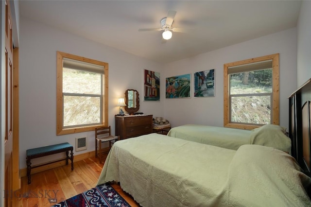 189 Quinn Creek Rd, Bozeman, MT 59715 - bedroom featuring baseboards, multiple windows, ceiling fan, and light wood-type flooring