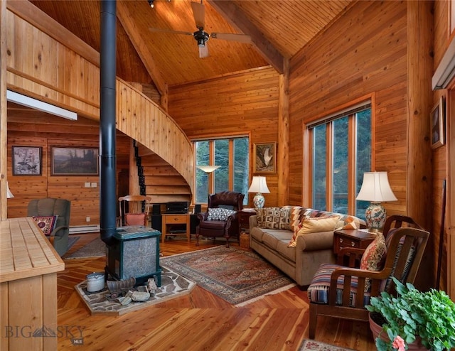 189 Quinn Creek Rd, Bozeman, MT 59715 - living area featuring a ceiling fan, high vaulted ceiling, a wood stove, wooden ceiling, and wooden walls