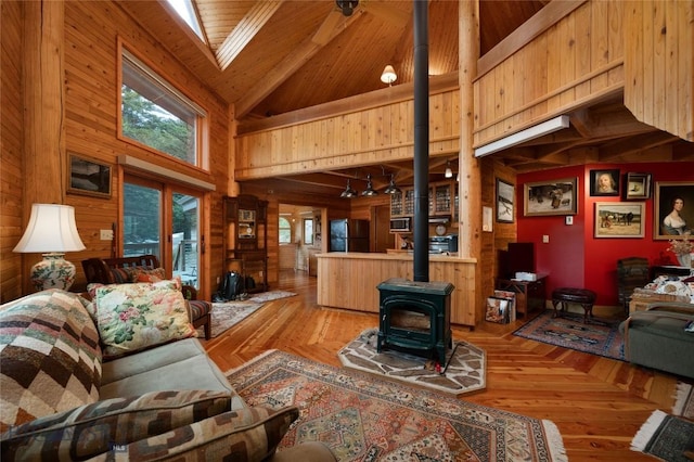 189 Quinn Creek Rd, Bozeman, MT 59715 - living room with a wood stove, beam ceiling, wooden walls, and high vaulted ceiling