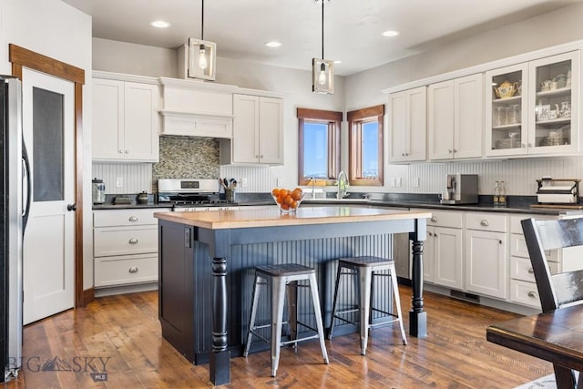 14549 High Flat Rd, Bozeman, MT 59718 - kitchen featuring stainless steel appliances, a kitchen breakfast bar, white cabinets, a center island, and backsplash