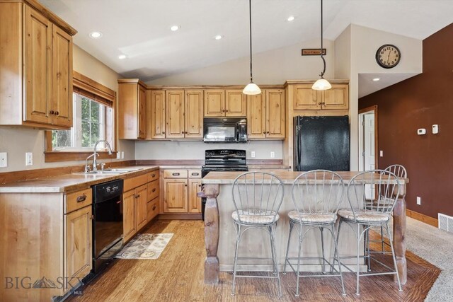 381 Bozeman Trail Rd, Bozeman, MT 59715 - kitchen featuring vaulted ceiling, a breakfast bar, a sink, a kitchen island, and black appliances
