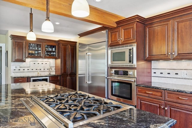 381 Bozeman Trail Rd, Bozeman, MT 59715 - kitchen featuring built in appliances, recessed lighting, hanging light fixtures, dark stone counters, and tasteful backsplash