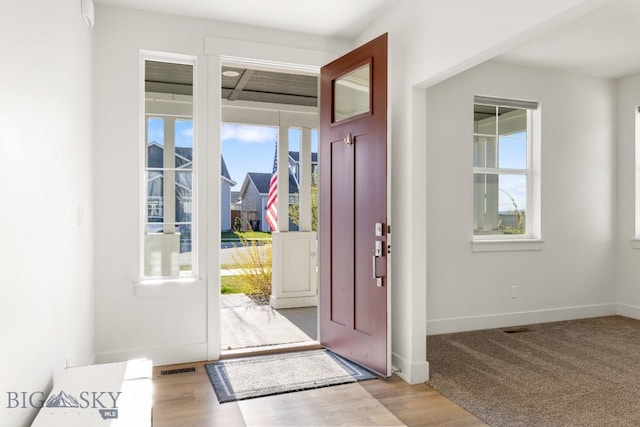 entrance foyer featuring wood finished floors, visible vents, and baseboards
