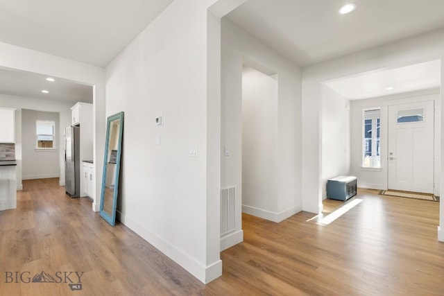 foyer featuring light wood-style floors, visible vents, baseboards, and recessed lighting