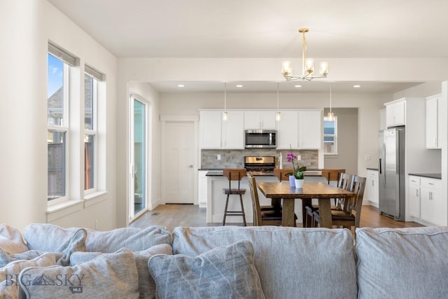 living area featuring recessed lighting, a notable chandelier, and wood finished floors