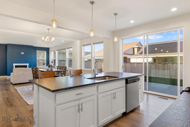 kitchen with a sink, dark wood-style flooring, visible vents, and dishwasher