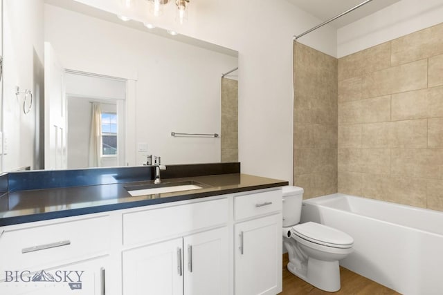bathroom with vanity, toilet, shower / tub combination, and wood finished floors