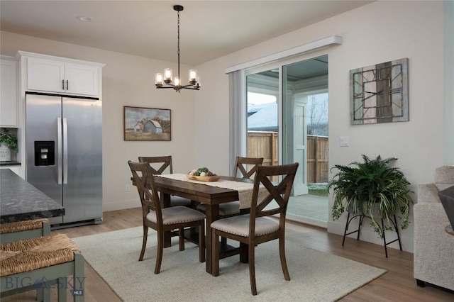 dining room featuring an inviting chandelier and light wood-style flooring