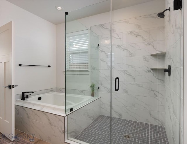 bathroom with a stall shower and a garden tub