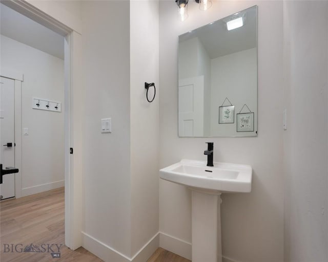 bathroom with baseboards and wood finished floors