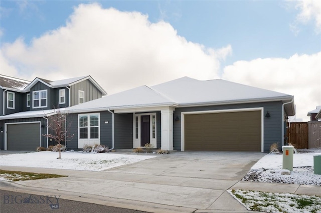 view of front facade featuring concrete driveway, a garage, fence, and board and batten siding
