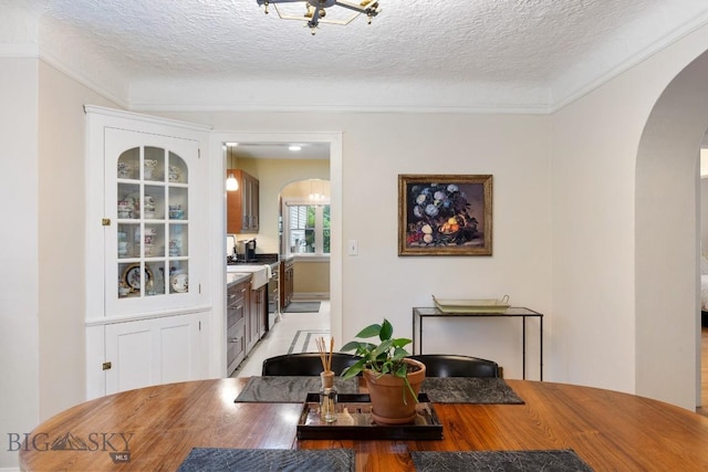 1014 S 6th St, Bozeman, MT 59715 - dining space featuring crown molding, a textured ceiling, and arched walkways