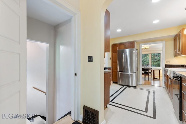 1014 S 6th St, Bozeman, MT 59715 - kitchen with freestanding refrigerator, brown cabinetry, visible vents, arched walkways, and recessed lighting