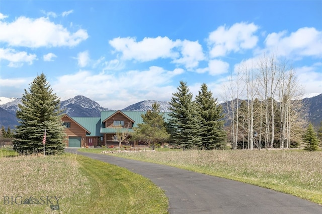 view of front facade with aphalt driveway, a mountain view, and a garage