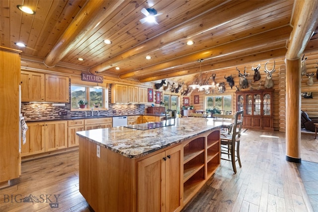 kitchen with white dishwasher, rustic walls, light wood-type flooring, and a wealth of natural light