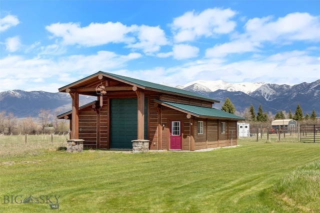exterior space with an outdoor structure, a mountain view, and fence