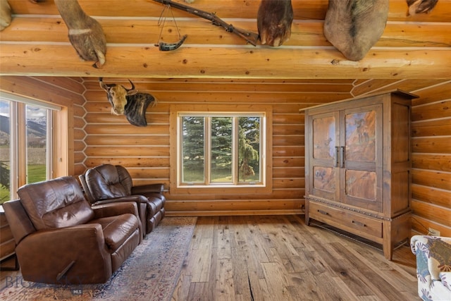 interior space featuring a healthy amount of sunlight, hardwood / wood-style floors, and rustic walls