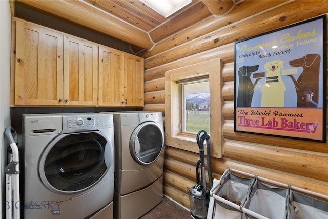 laundry room featuring cabinet space, washing machine and dryer, dark tile patterned floors, and log walls